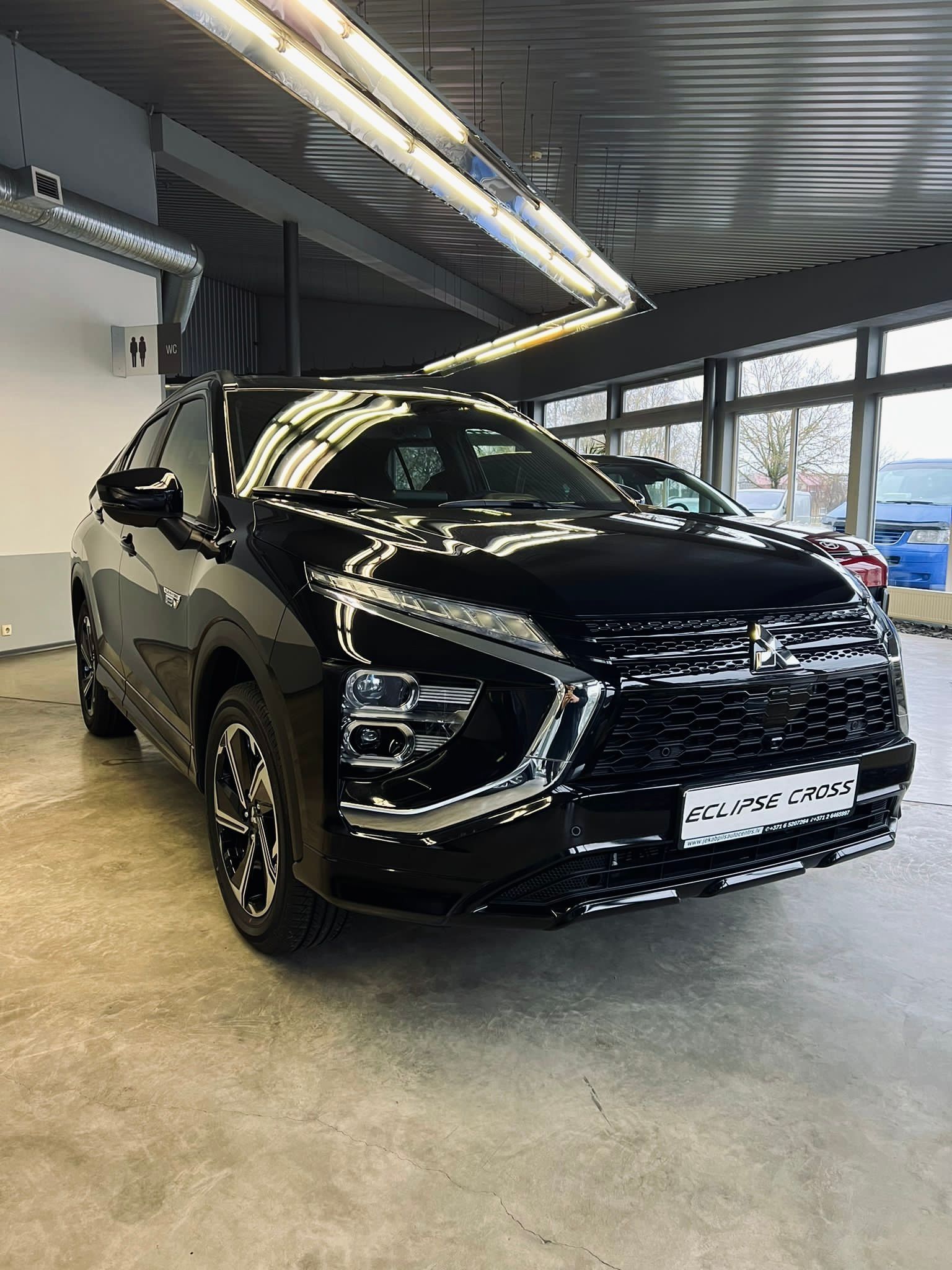 Melna mašīna stāv garāžā.