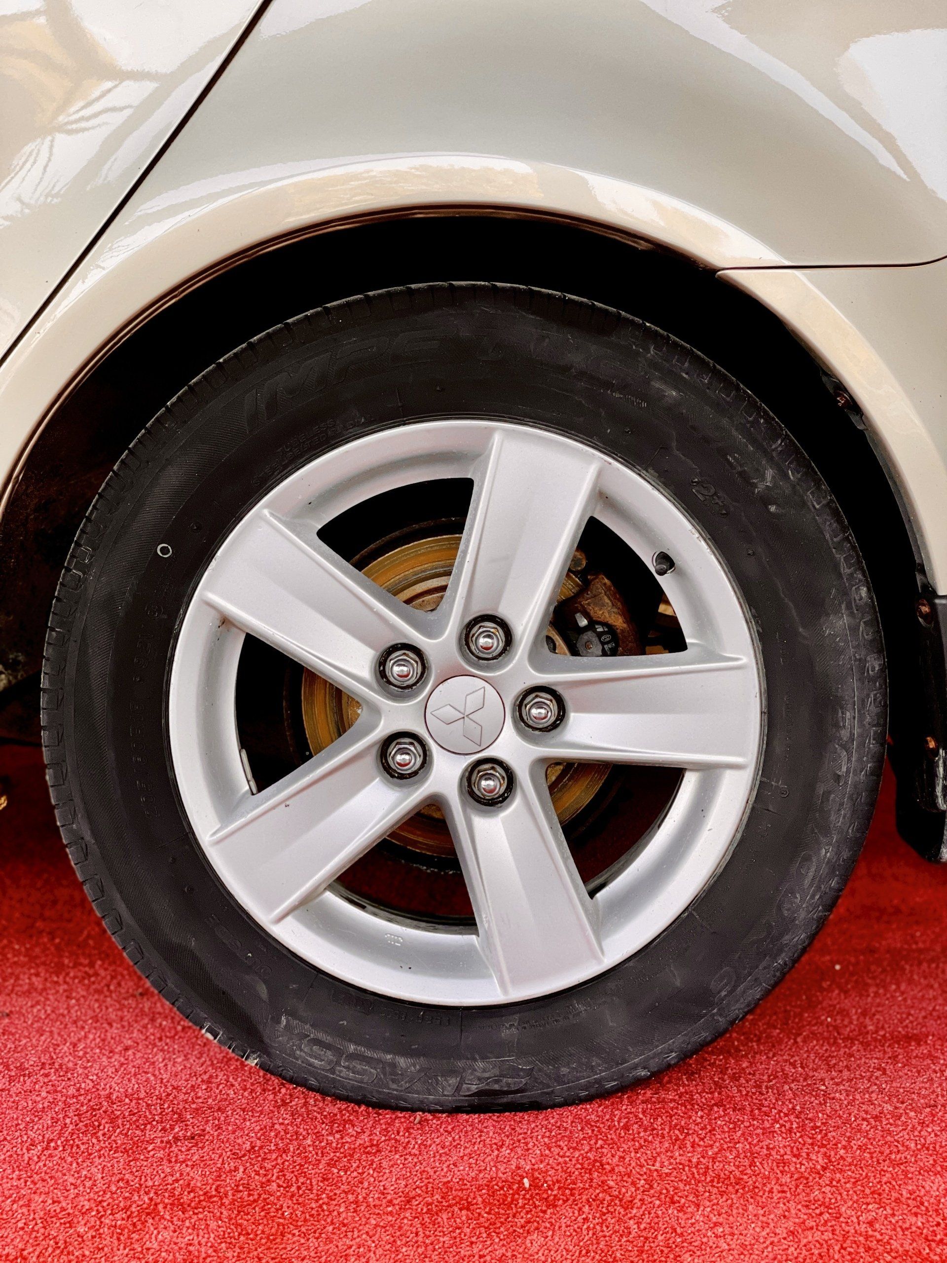 Tuvplāns ar automašīnas riteni uz sarkanā paklāja