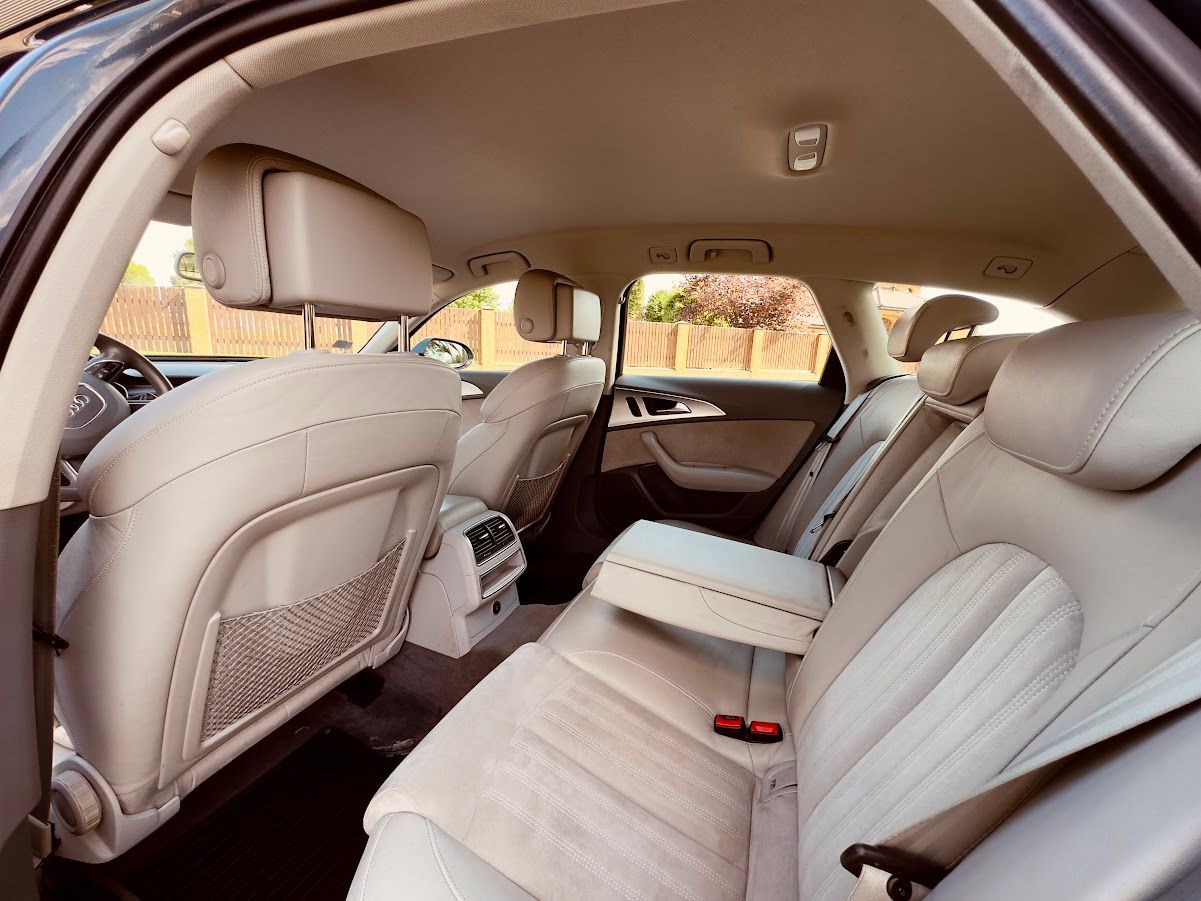 Automašīnas aizmugurējais sēdeklis ar baltiem ādas sēdekļiem