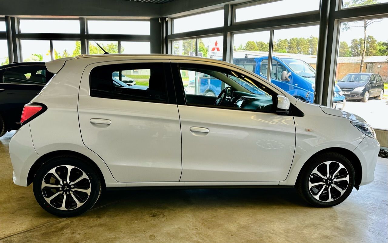 Balts mitsubishi mirage hečbeks sēž izstāžu zālē.