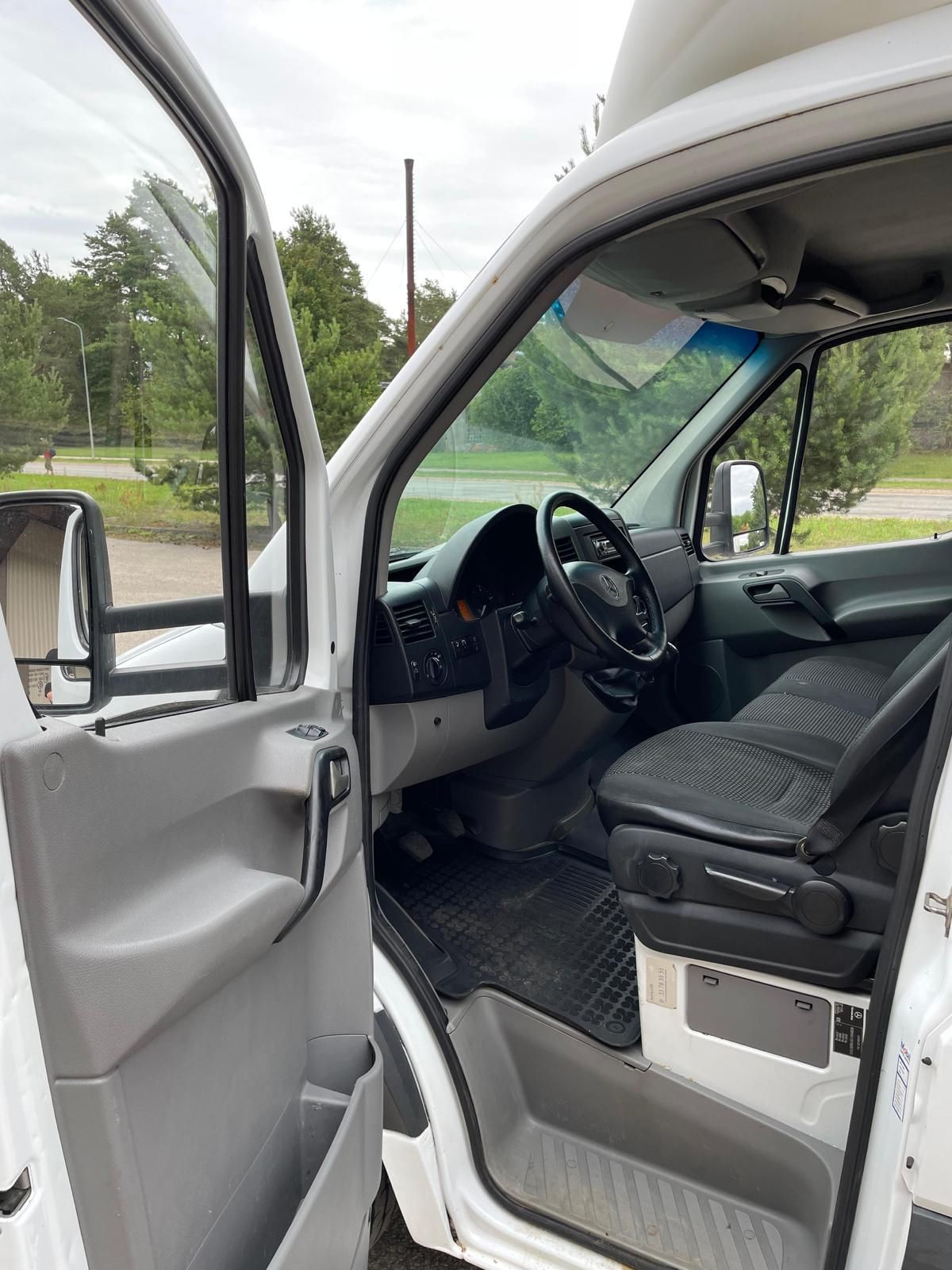 Balta furgona iekšpuse ar atvērtām durvīm