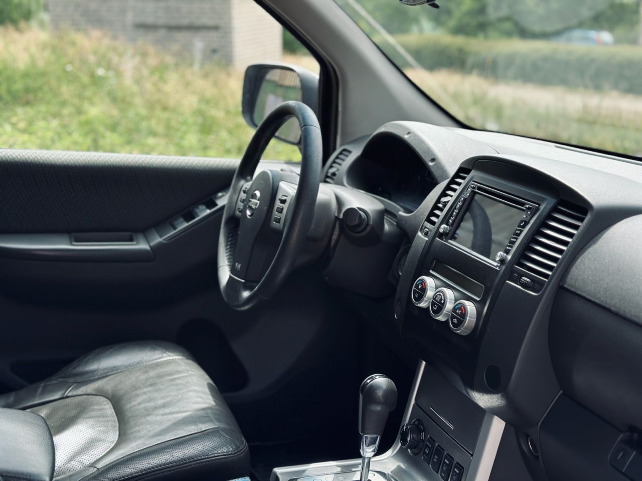 Automašīnas iekšpuse ar stūri un instrumentu paneli