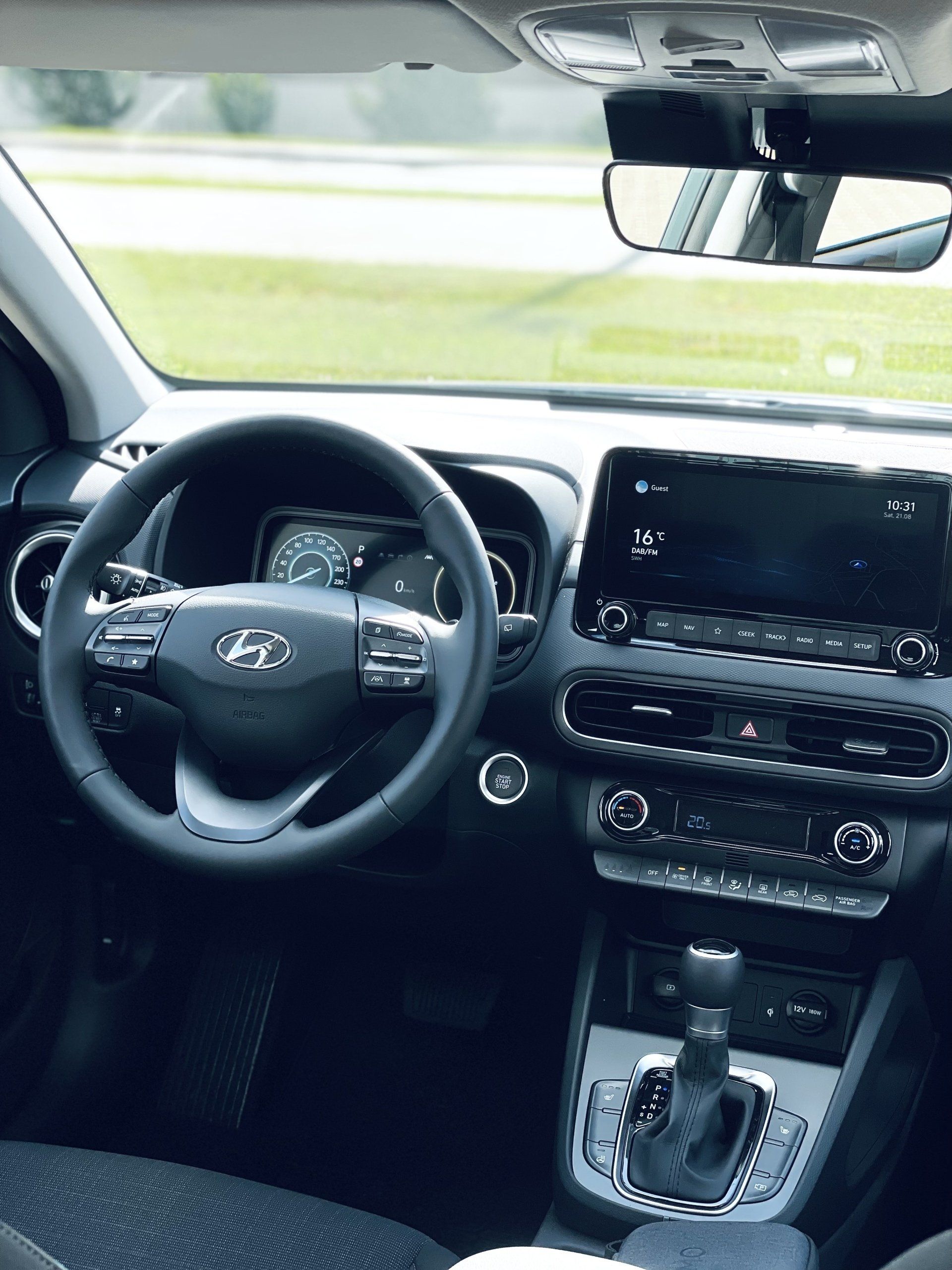 Hyundai kona interjers ar stūri un atpakaļskata spoguli.