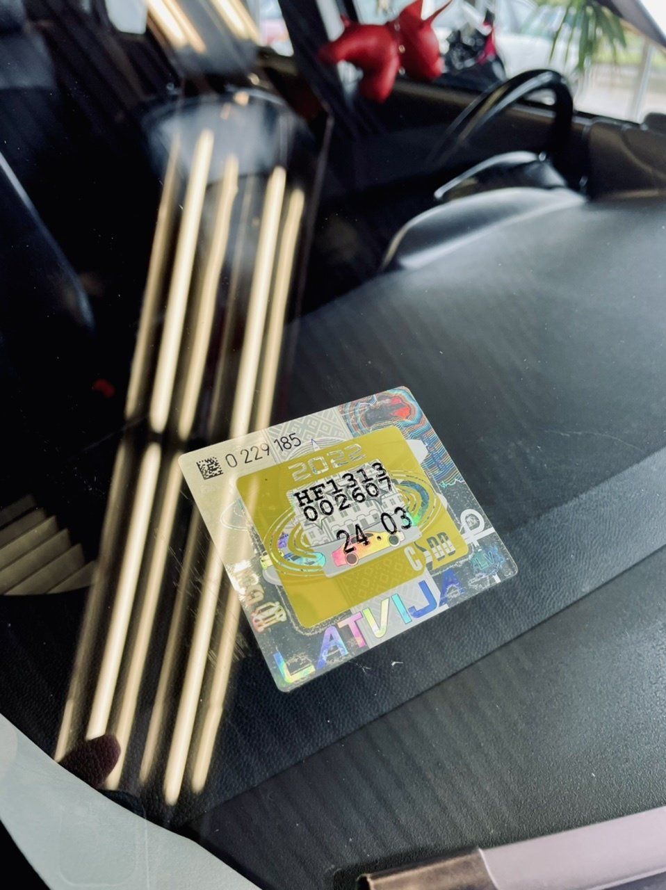 Dzeltena uzlīme uz automašīnas vējstikla