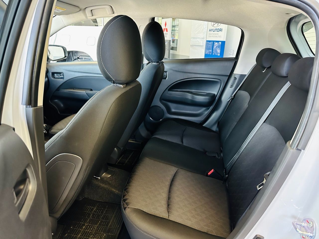 Baltas automašīnas aizmugurējais sēdeklis ar melniem sēdekļiem