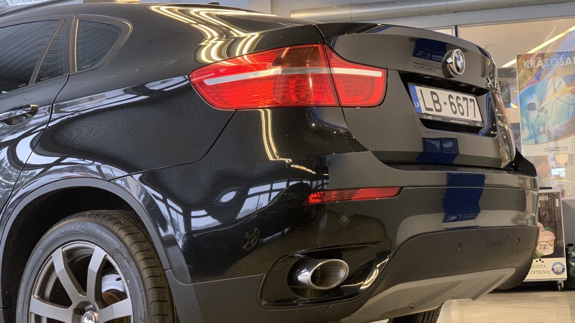 Melns bmw x6 stāv salonā.