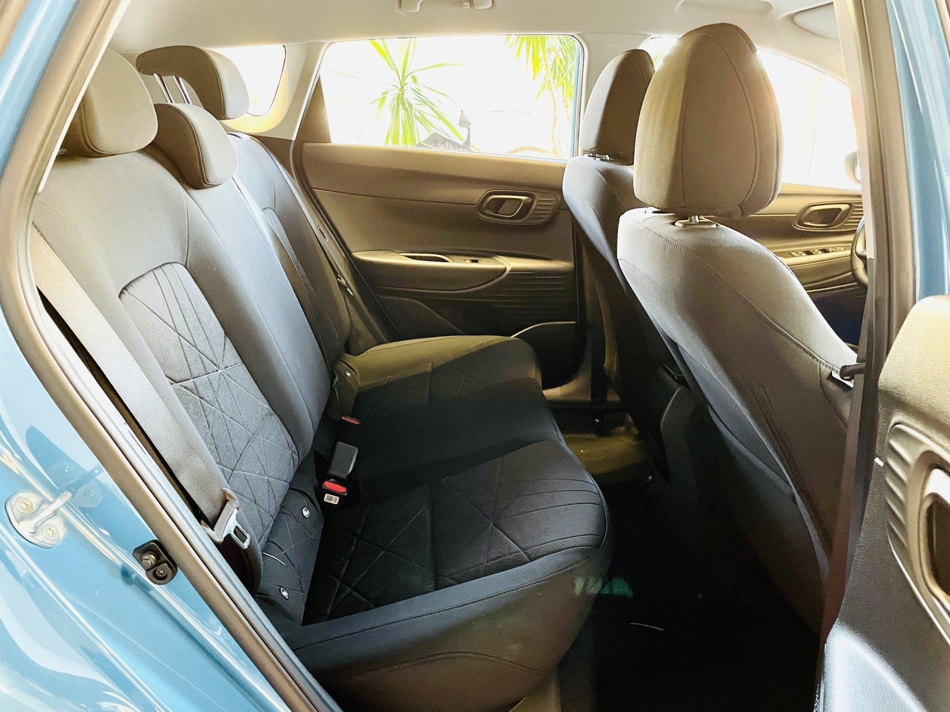 Zilas automašīnas aizmugurējais sēdeklis ar melniem sēdekļiem