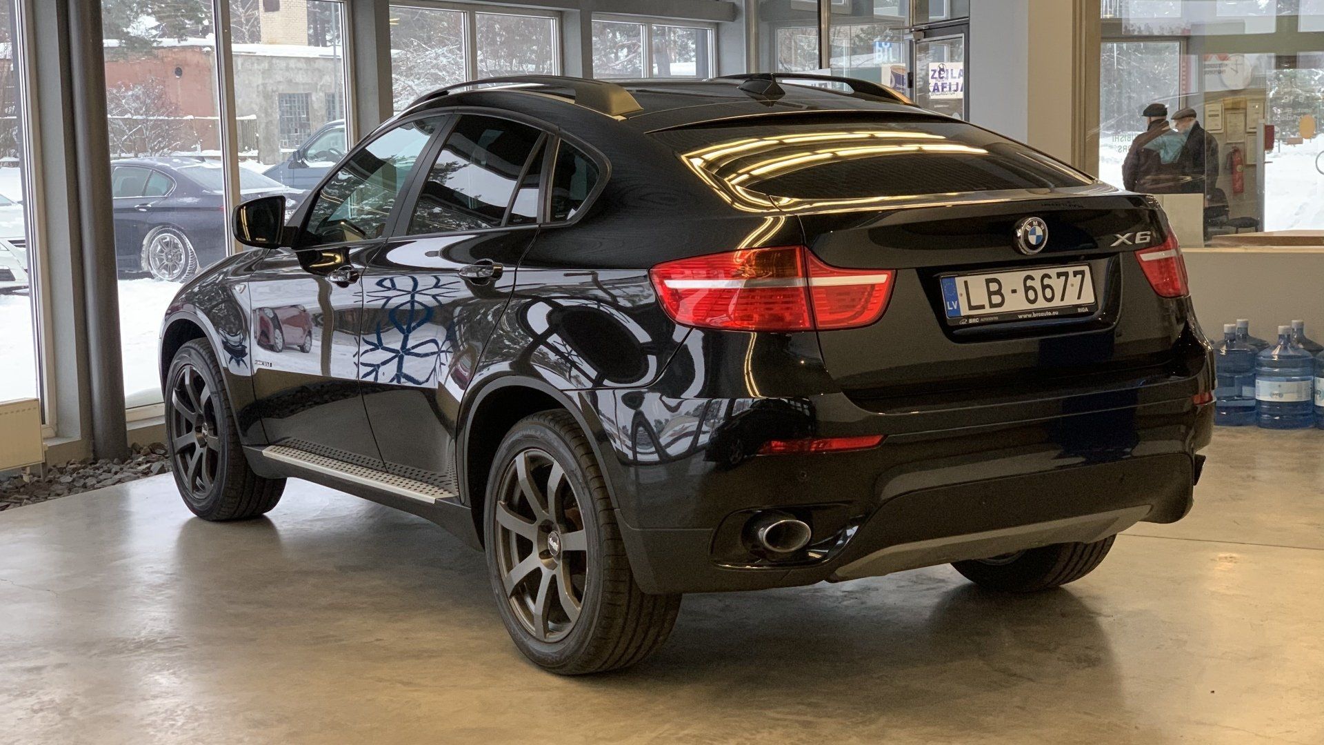 Melns bmw x6 stāv salonā.