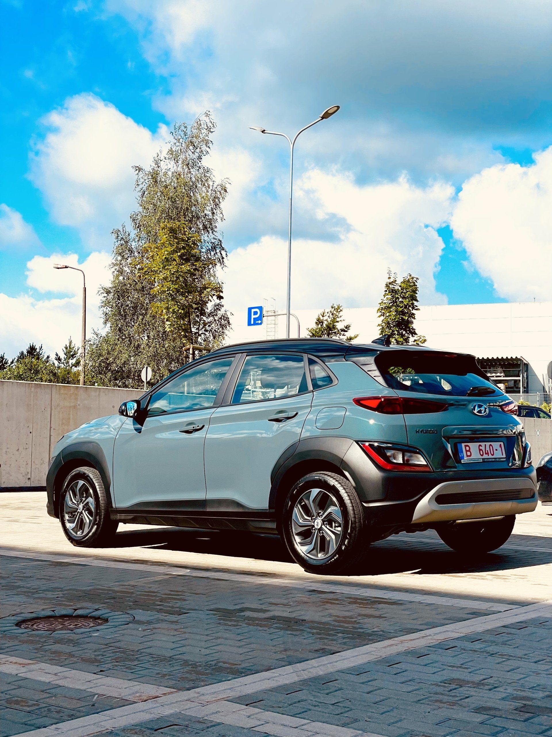 Automašīna ir novietota stāvvietā ar zilām debesīm fonā.