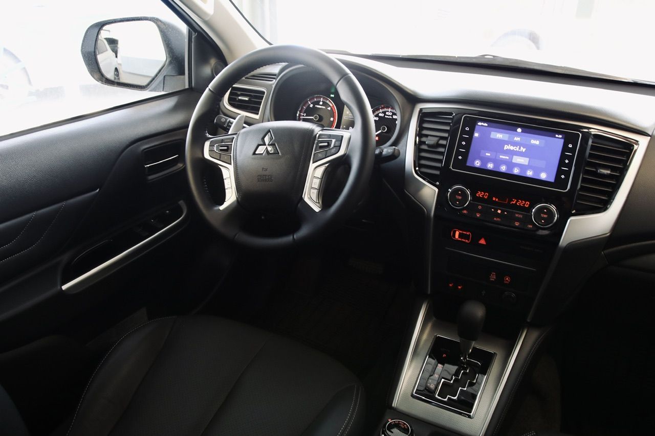 Automašīnas salons ar stūri un radio.