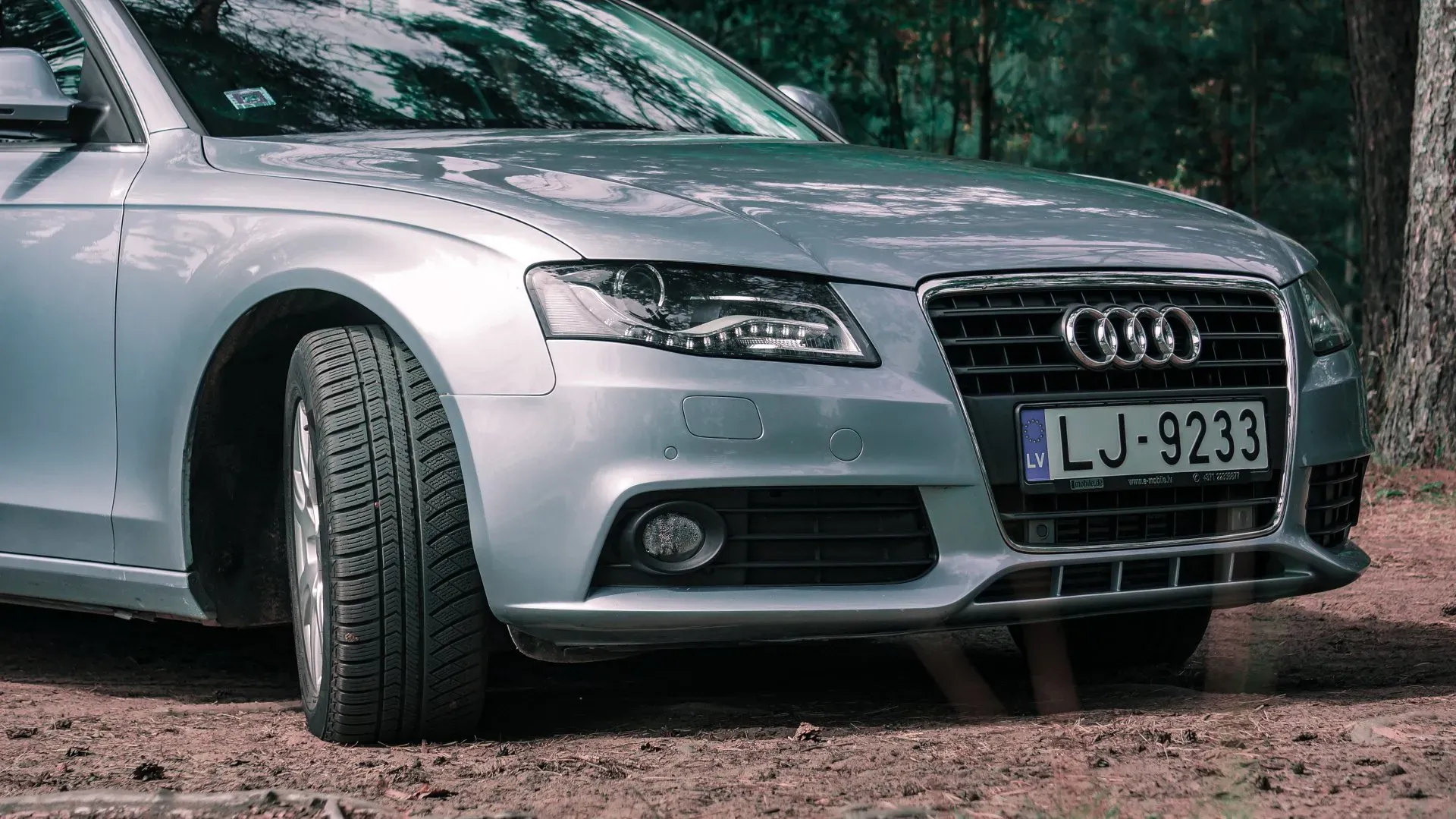 Sudraba audi ar numura zīmi, kurā rakstīts lj 9233, ir novietots netīrumos.