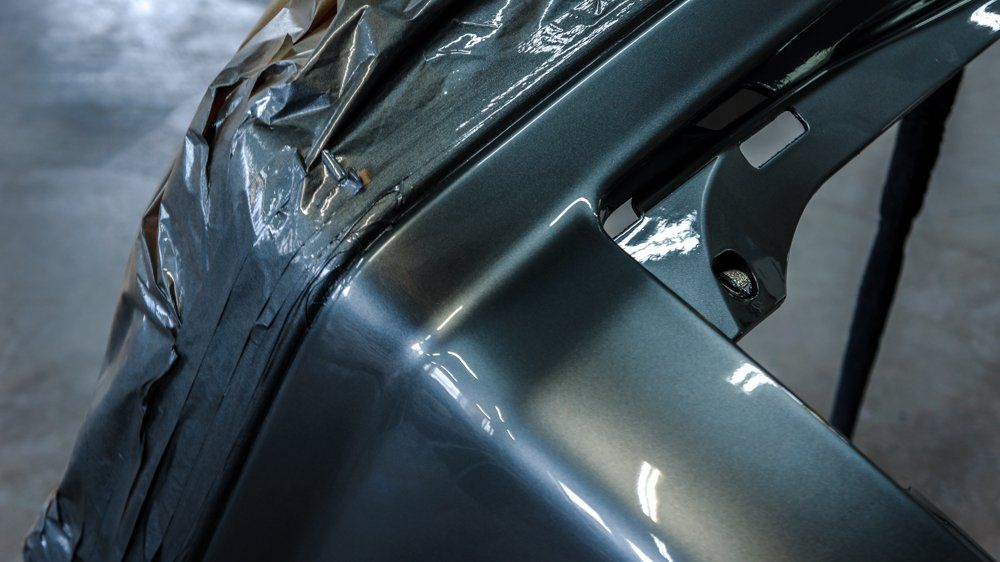 Automašīnas buferis ir ietīts plastmasā un sēž uz galda.