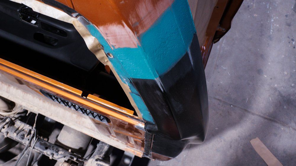 Tuvplāns ar automašīnas durvīm, kuras tiek remontētas