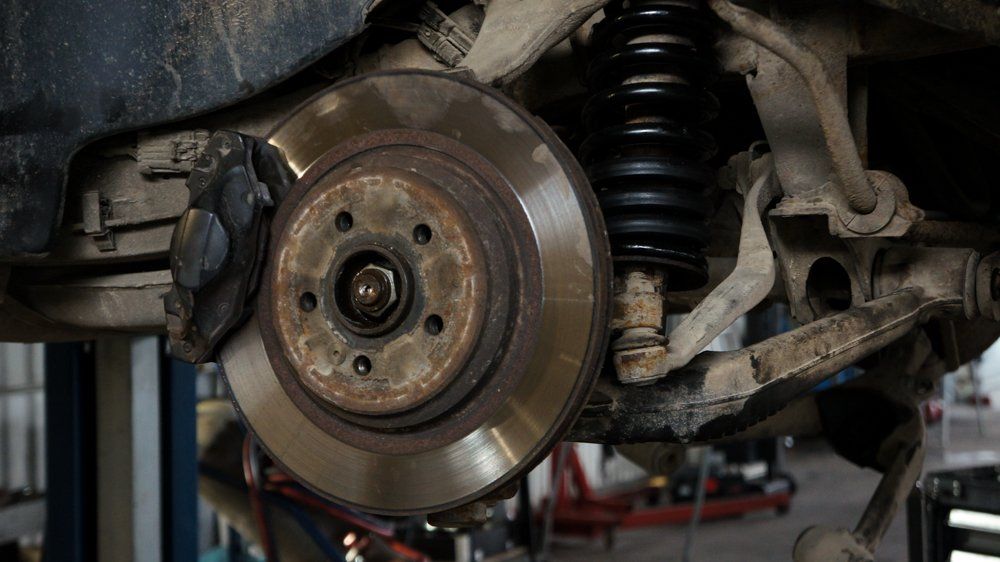 Bremžu diska tuvplāns uz automašīnas garāžā.