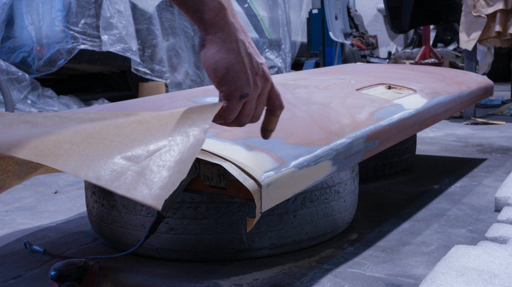 Cilvēks tur plastmasas gabalu virs vējdēļa.