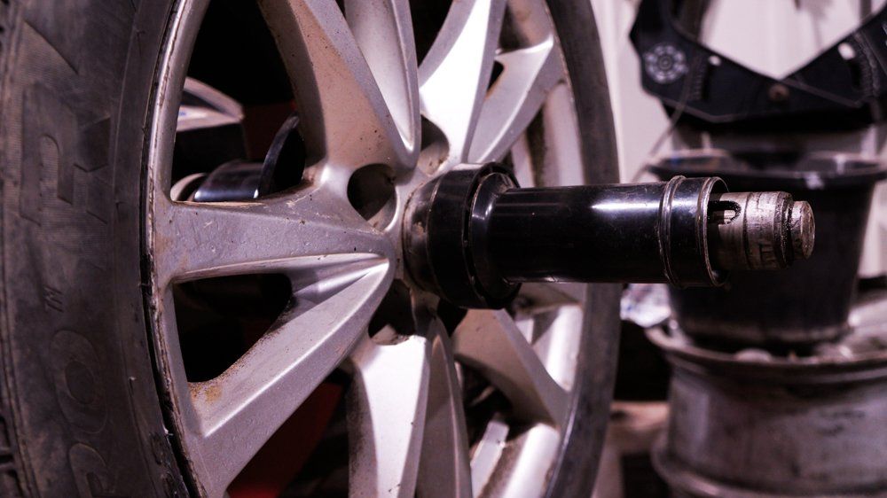 Tuvplāns no automašīnas riteņa ar riepu uz tā.