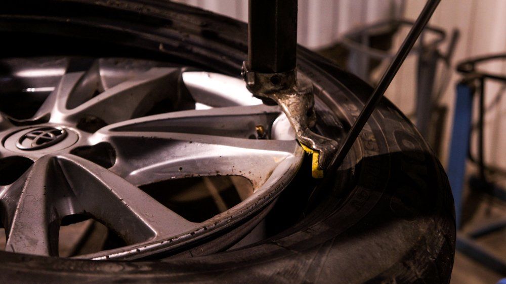 Riepu maina ar mašīnu garāžā.