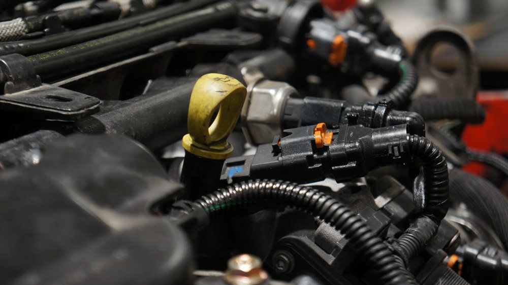 Tuvplāns automašīnas dzinējam ar dzeltenu eļļas mērstieni.