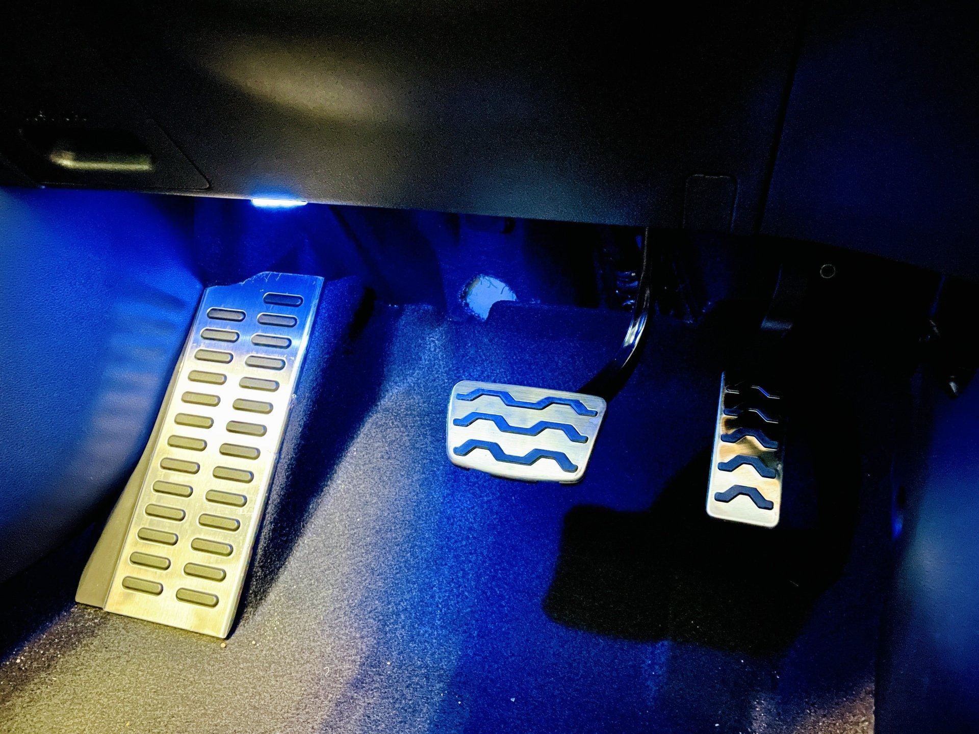 Tuvplāns no automašīnas pedāļiem ar zilām gaismām