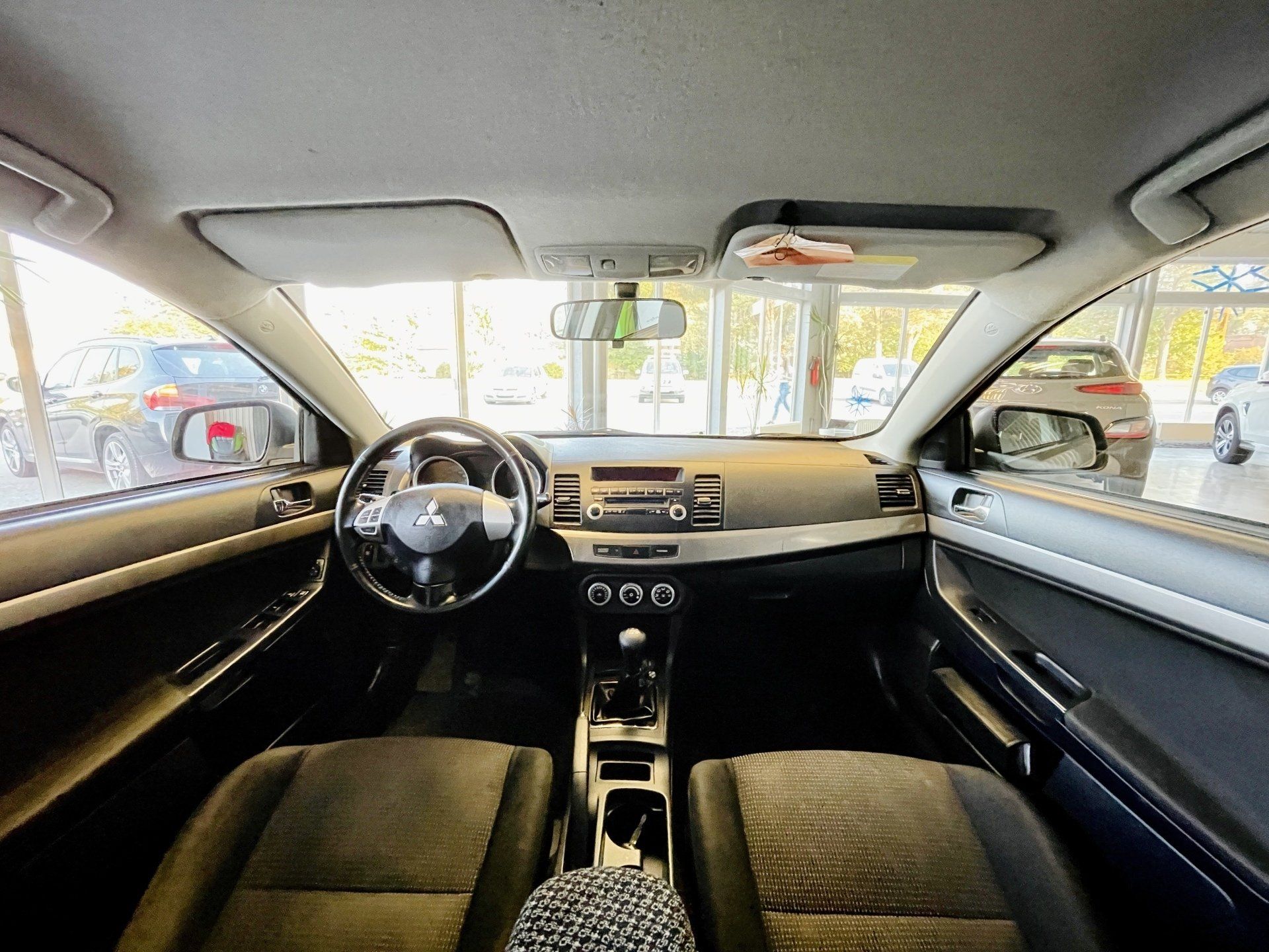 Automašīnas iekšpuse ar stūri un instrumentu paneli.