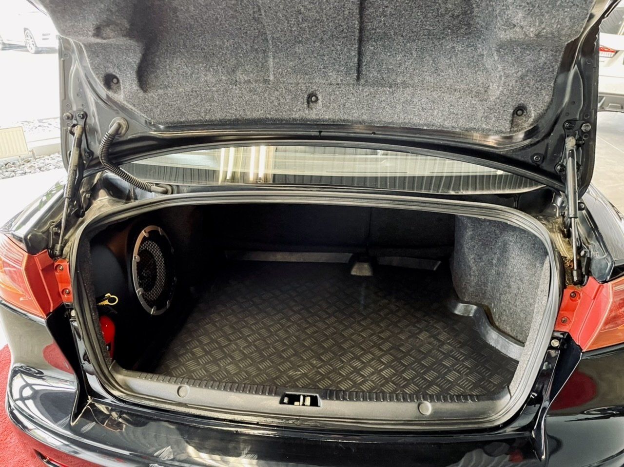 Melnas automašīnas bagāžnieks ar atvērtu motora pārsegu