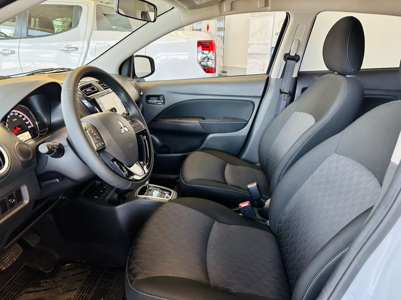 Automašīnas iekšpuse ar melniem sēdekļiem un stūri