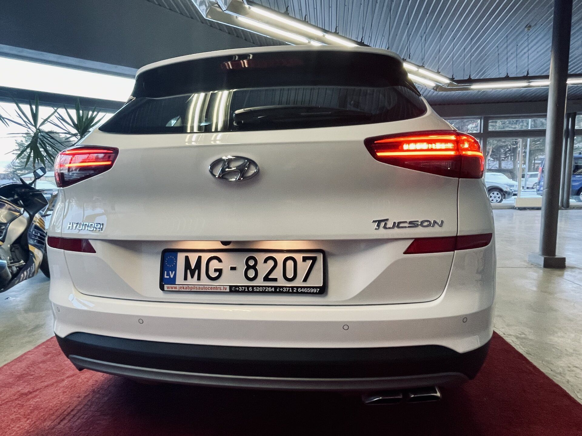 Balts hyundai tucson ir novietots izstāžu zālē