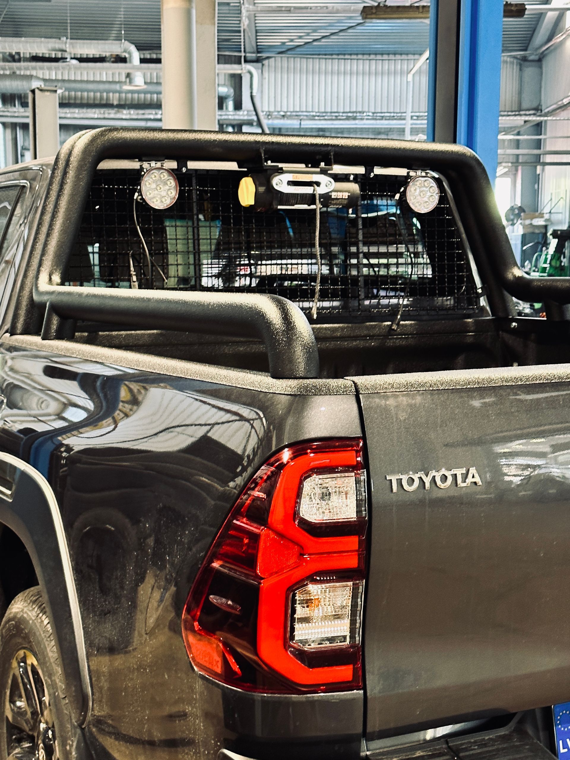 Melna toyota kravas automašīna ir novietota garāžā.