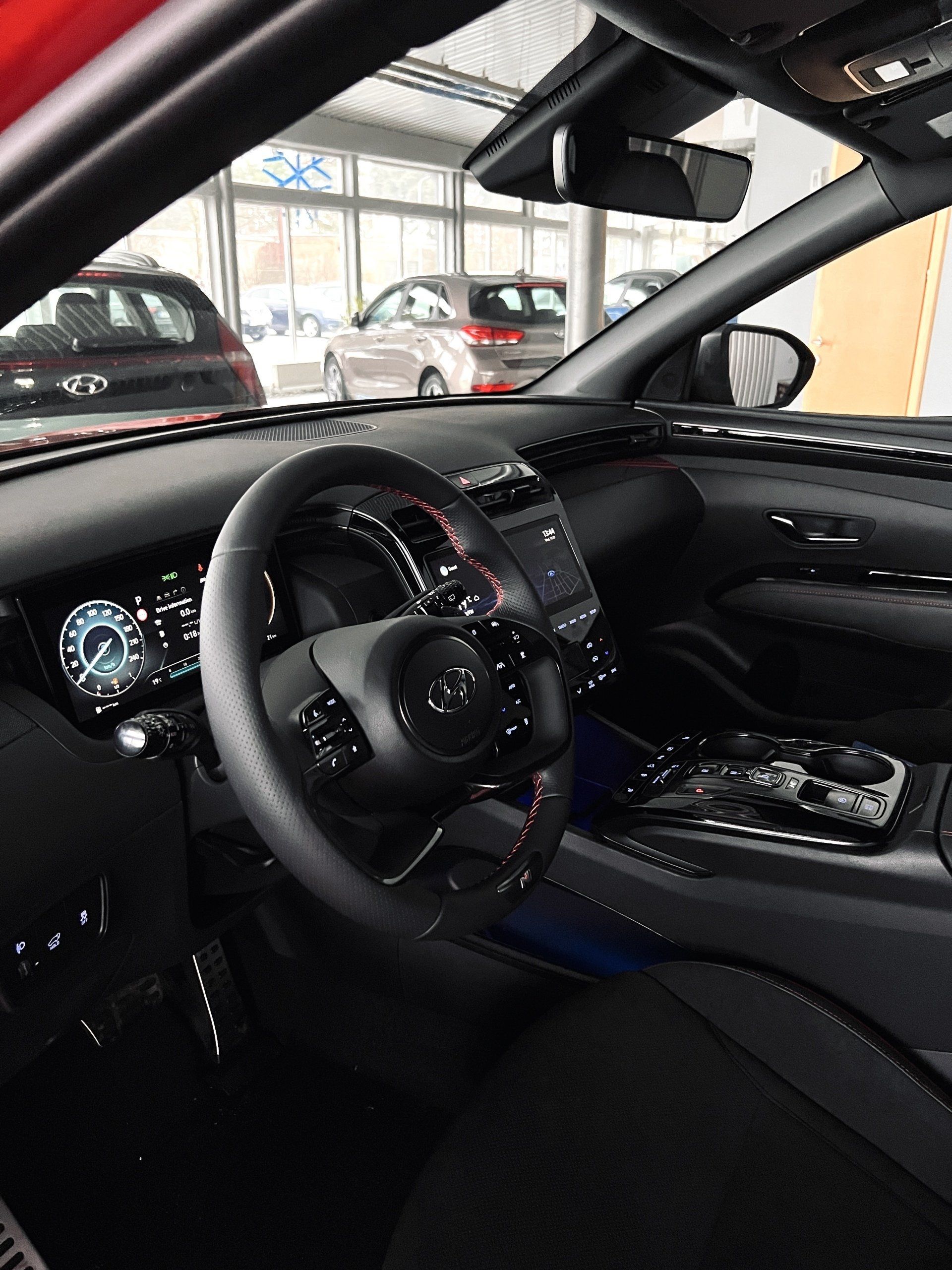 Automašīnas iekšpuse ar stūri un instrumentu paneli.