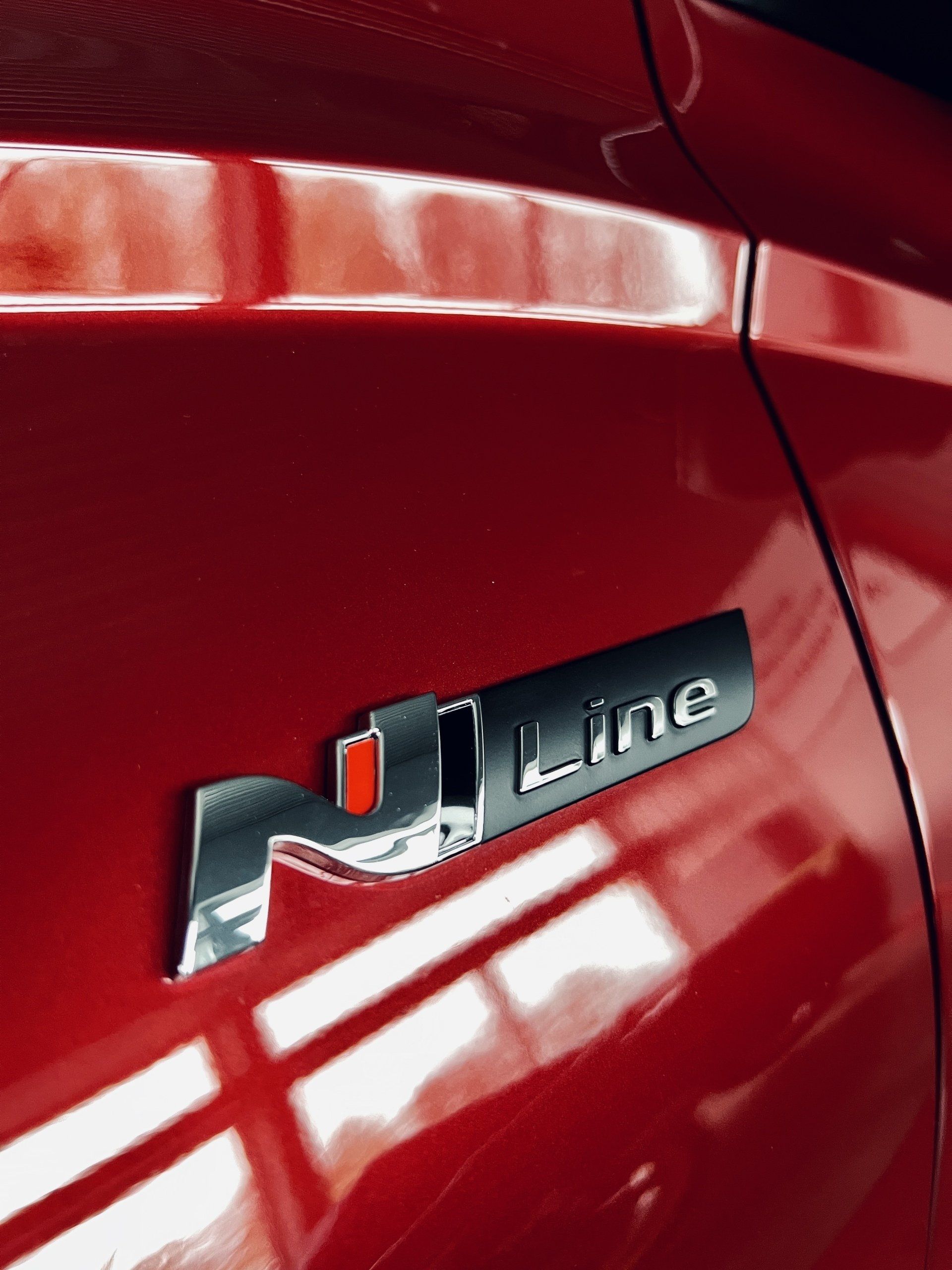 Sarkana automašīna ar uzrakstu uz sāniem