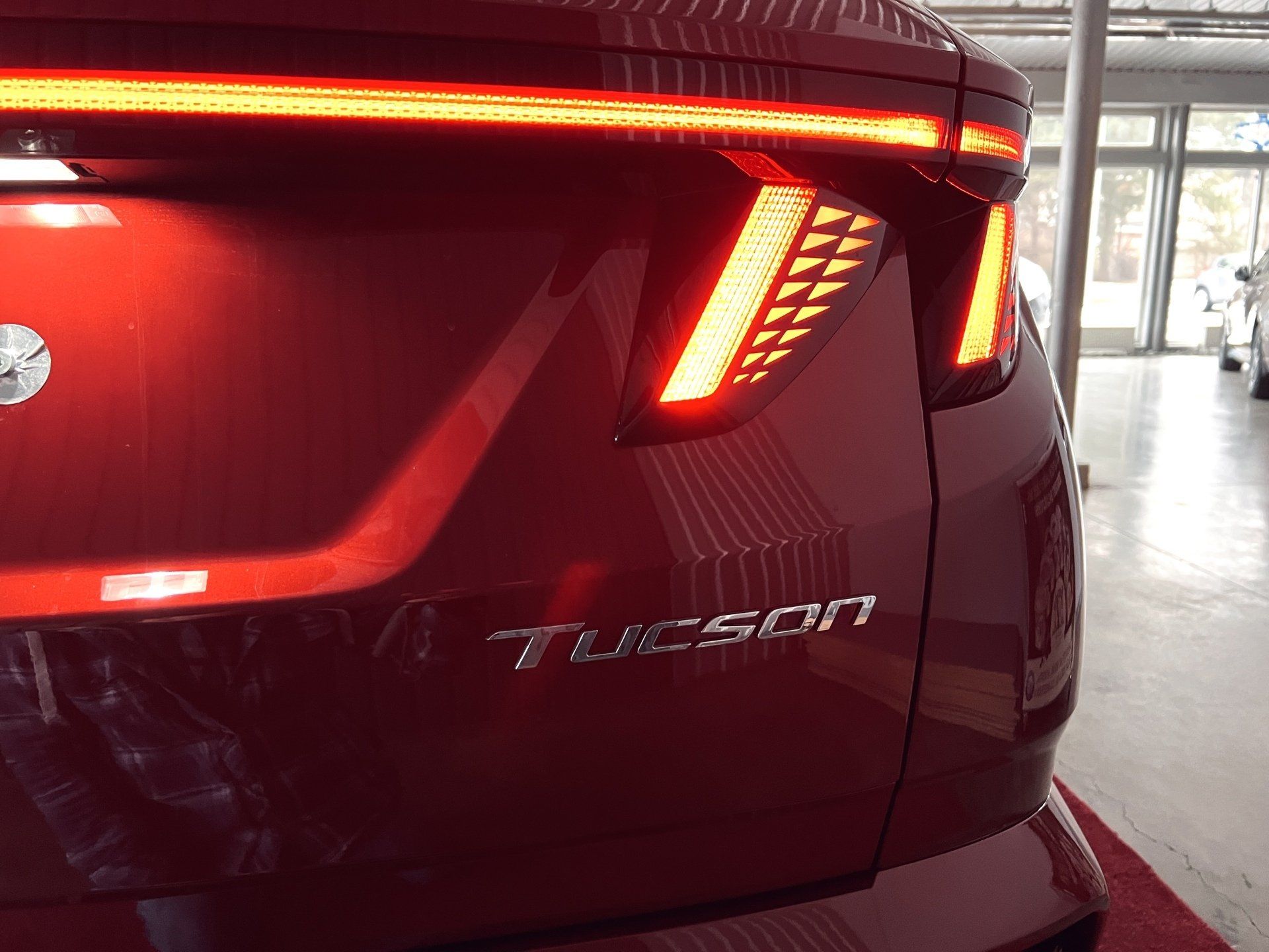 Sarkans hyundai tucson ir novietots izstāžu zālē