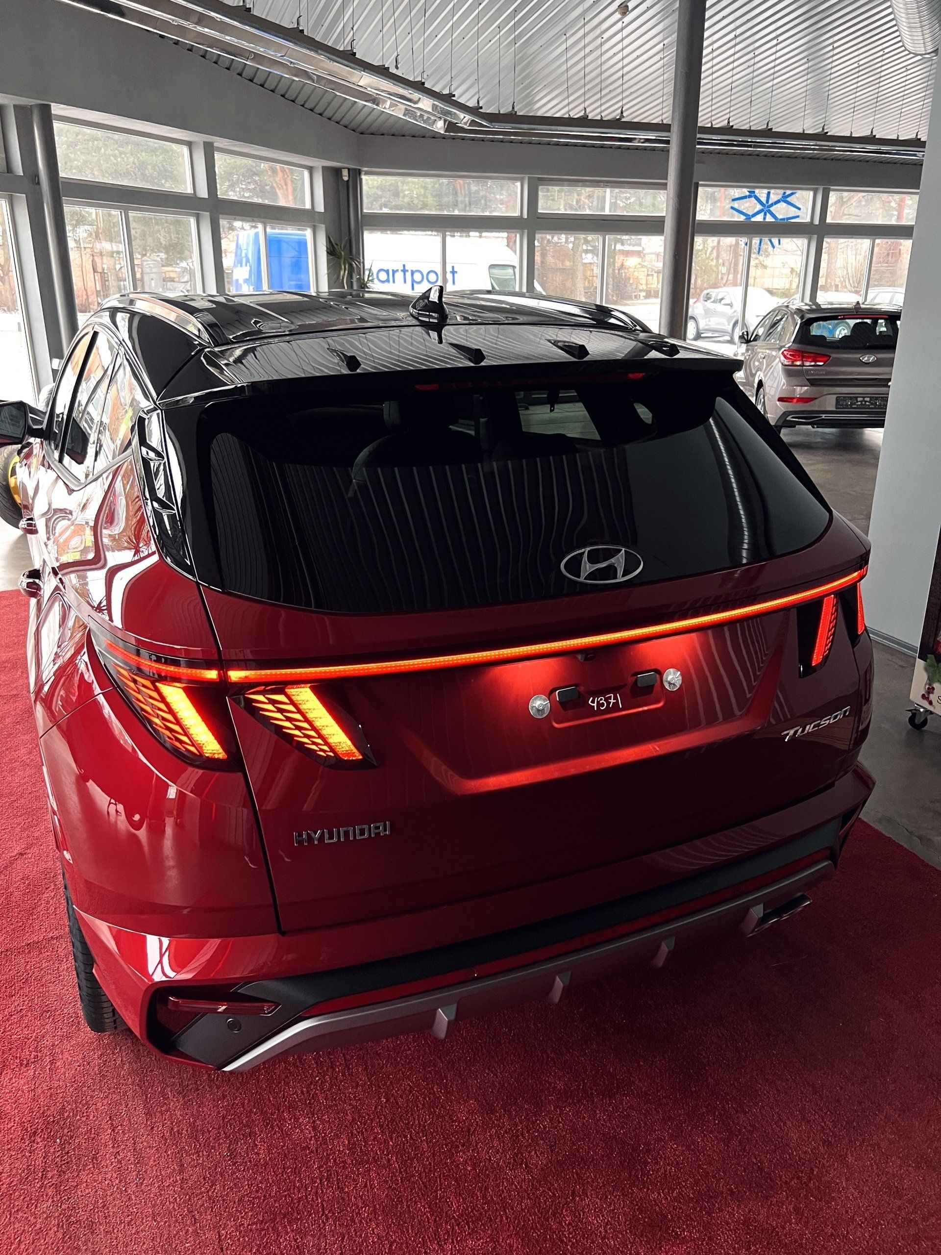 Sarkans hyundai tucson ir novietots izstāžu zālē.