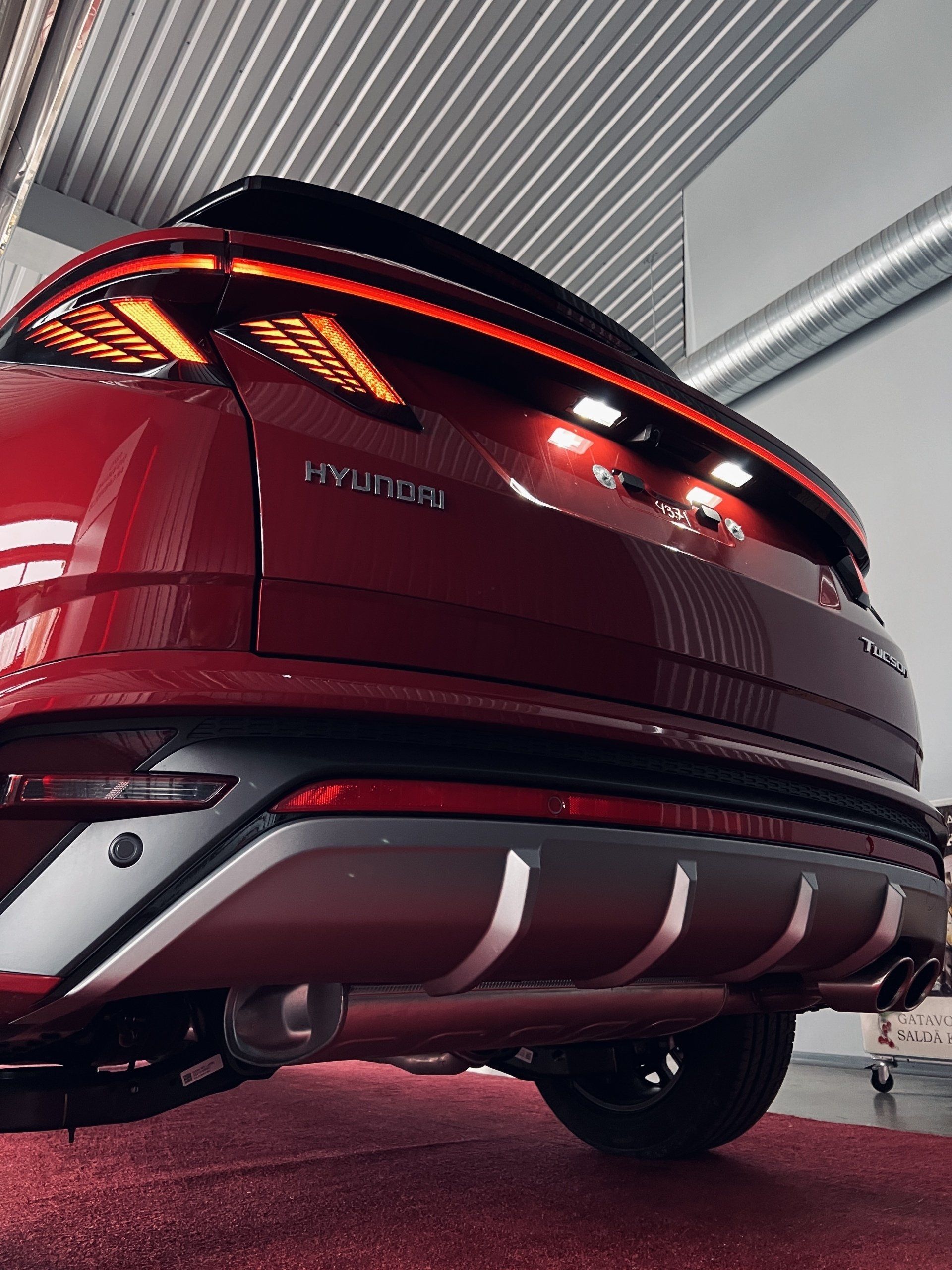 Sarkana hyundai automašīna ir novietota garāžā.