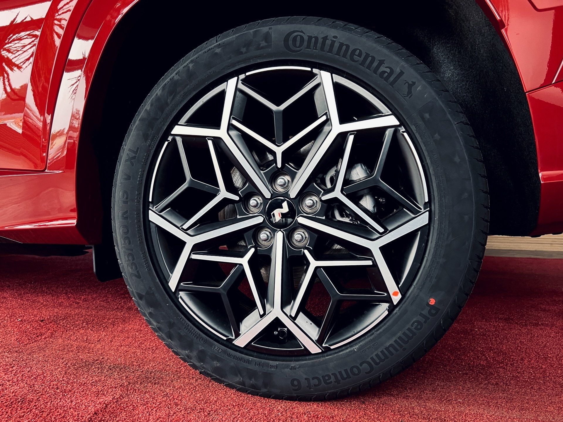 Tuvplāns no automašīnas riteņa ar kontinentālo riepu uz tā.