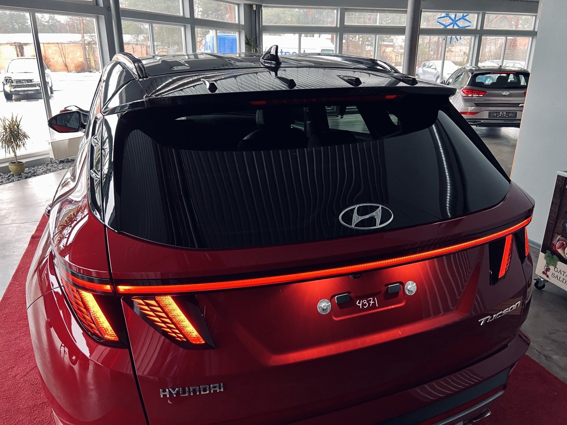 Sarkans hyundai tucson ir novietots izstāžu zālē.