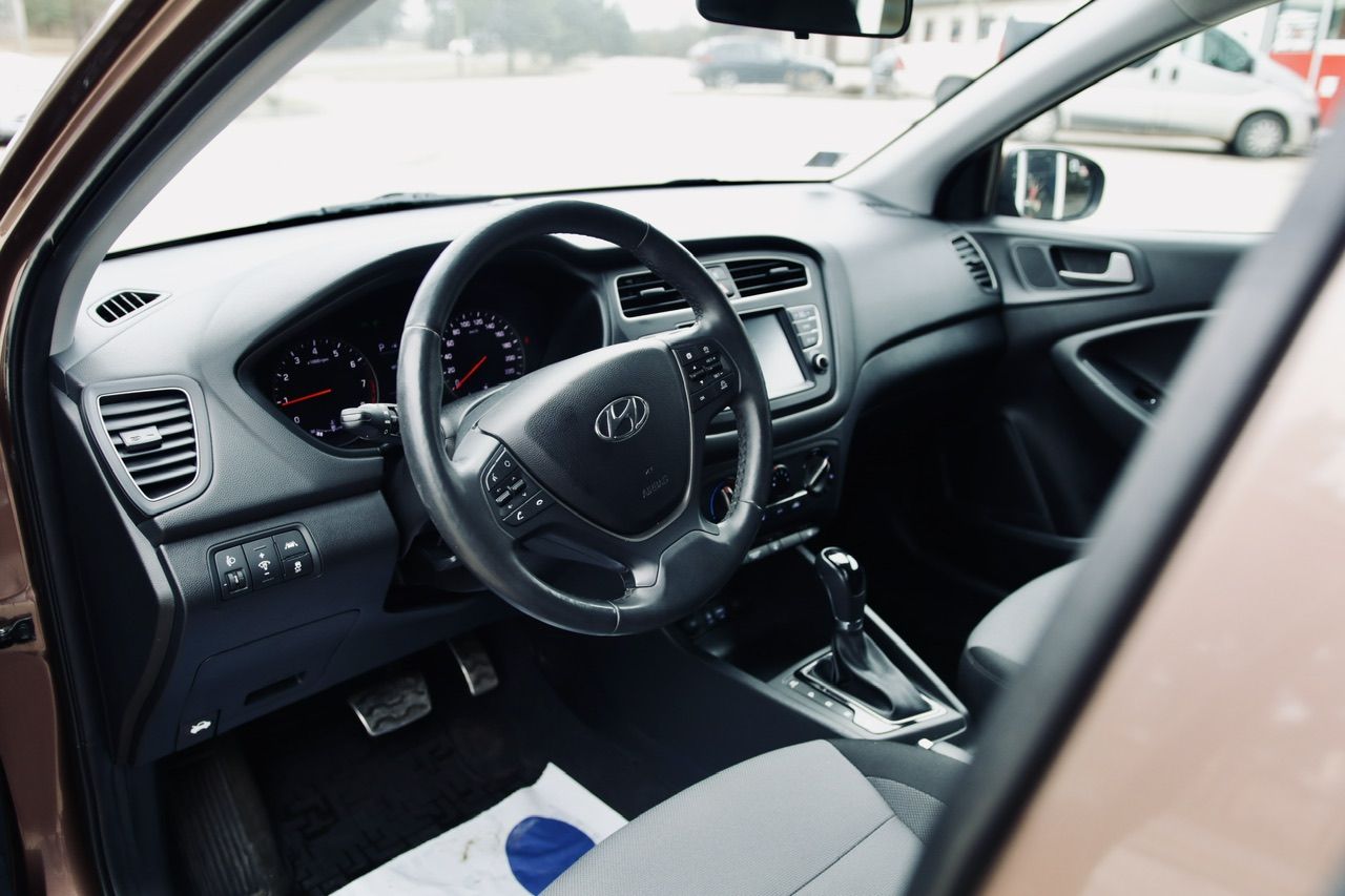 Automašīnas iekšpuse ar atvērtām durvīm un redzamu stūri.