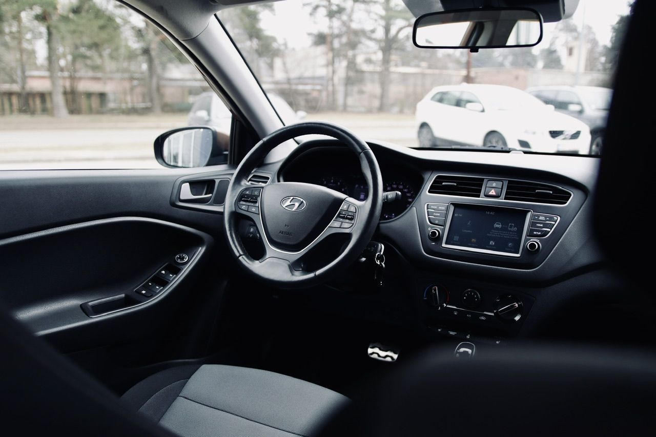 Automašīnas salons ar stūri un radio.