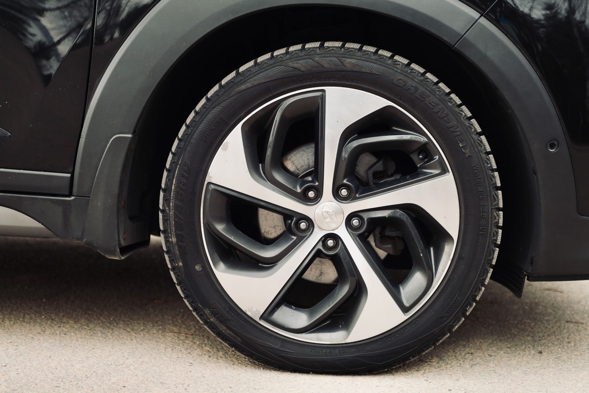 Tuvplāns no automašīnas riteņa ar riepu uz tā.