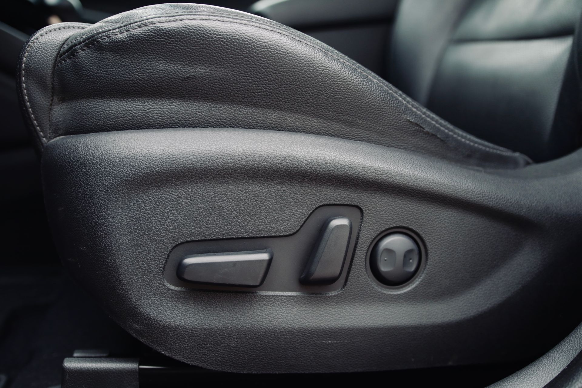 Tuvplāns no automašīnas sēdekļa ar pogu uz tā.