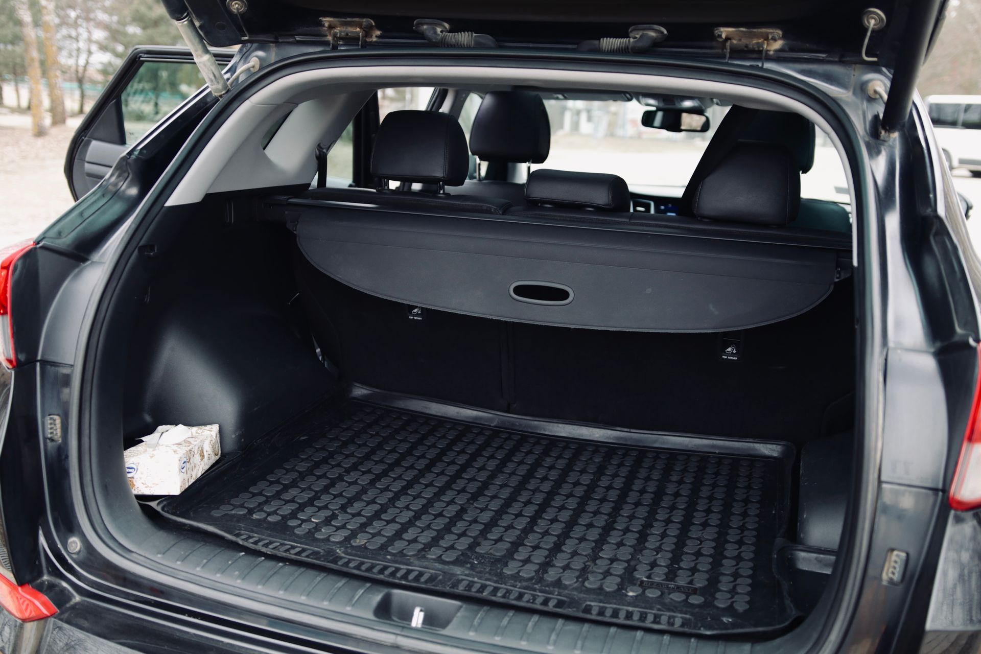 Melnas automašīnas bagāžnieks ar atvērtu bagāžnieka vāku.