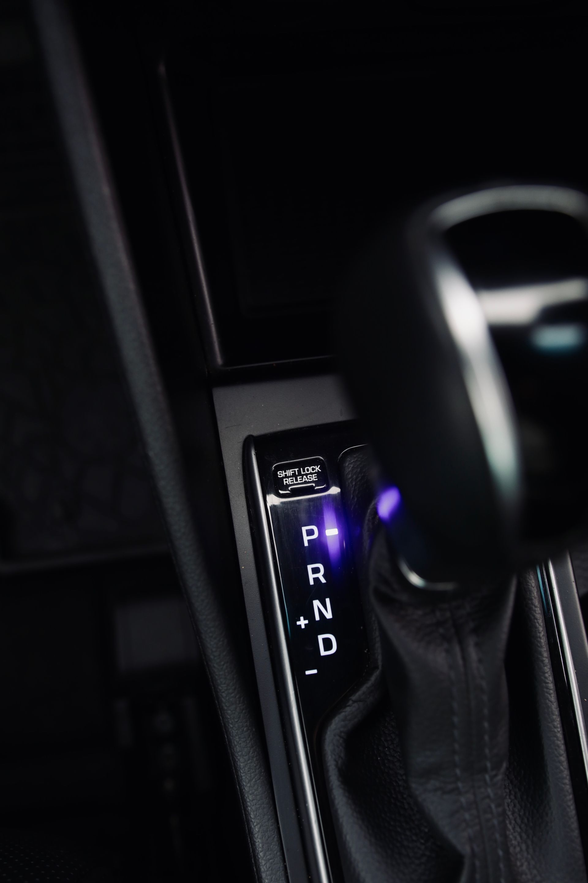 Tuvplāns ar automašīnas pārslēdzēju ar purpursarkanu gaismu uz tā