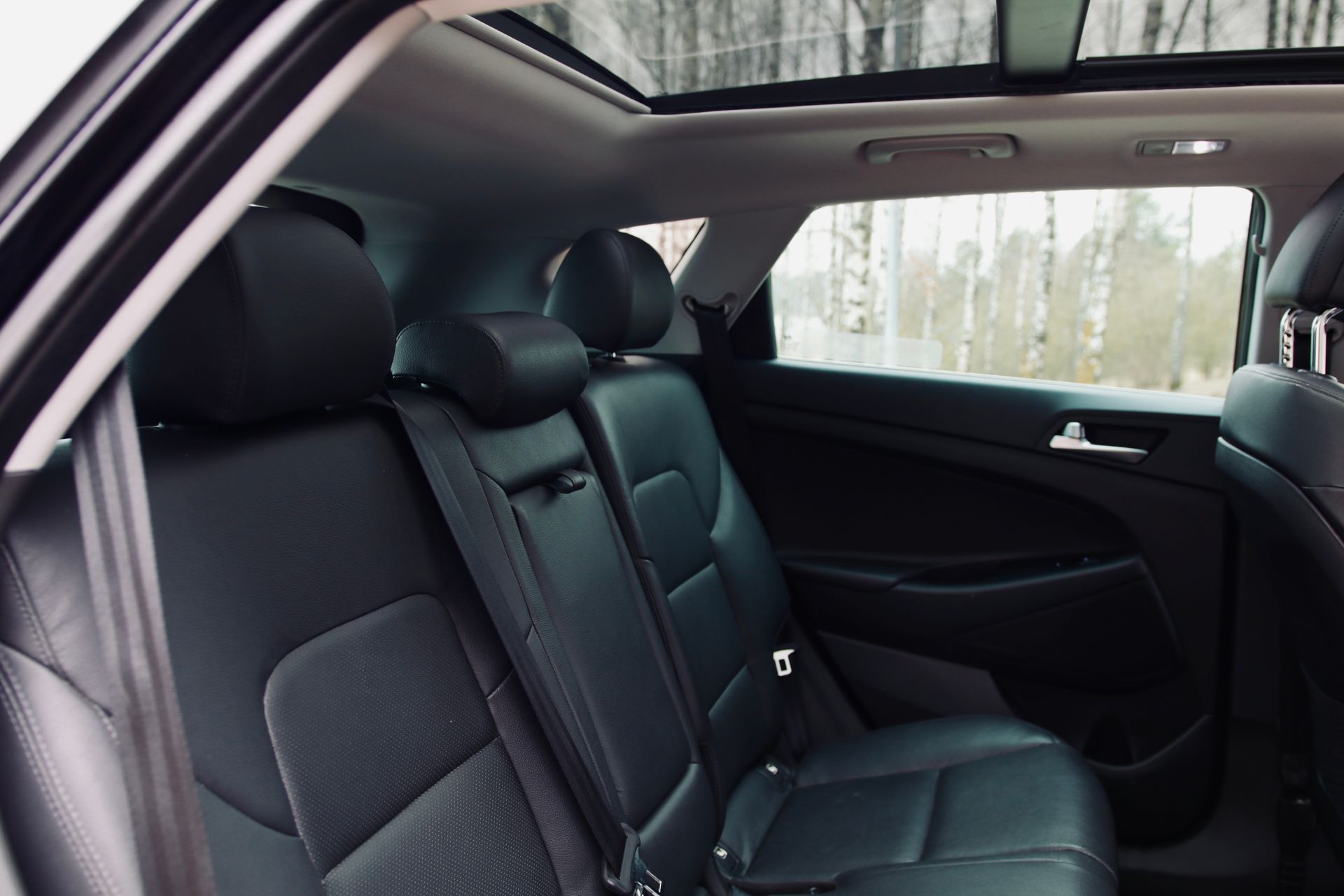 Automašīnas aizmugurējais sēdeklis ar jumta lūku