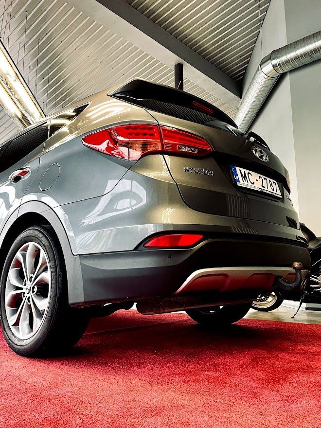 Automašīna ir novietota uz sarkanā paklāja salonā.