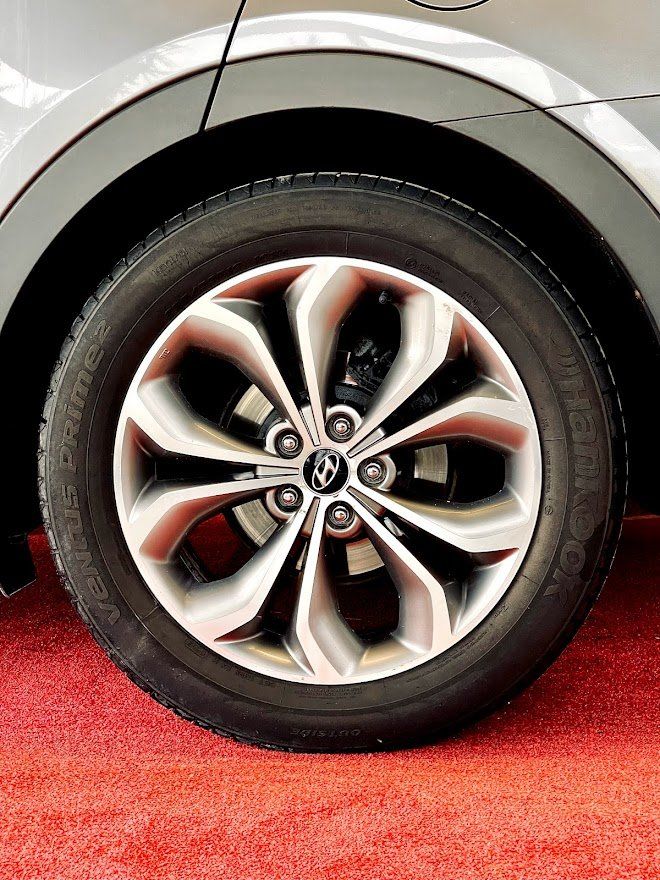 Tuvplāns ar automašīnas riteni uz sarkanā paklāja