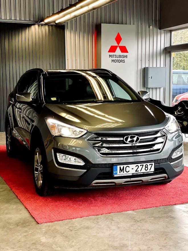 Pelēka hyundai santa fe ir novietota izstāžu zālē.