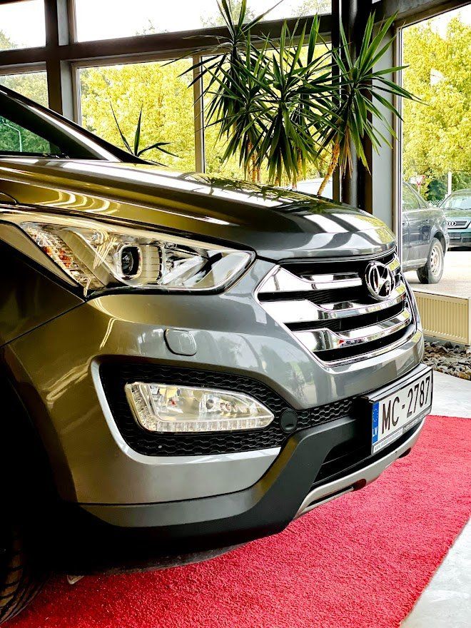 Automašīna ir novietota uz sarkanā paklāja salonā.