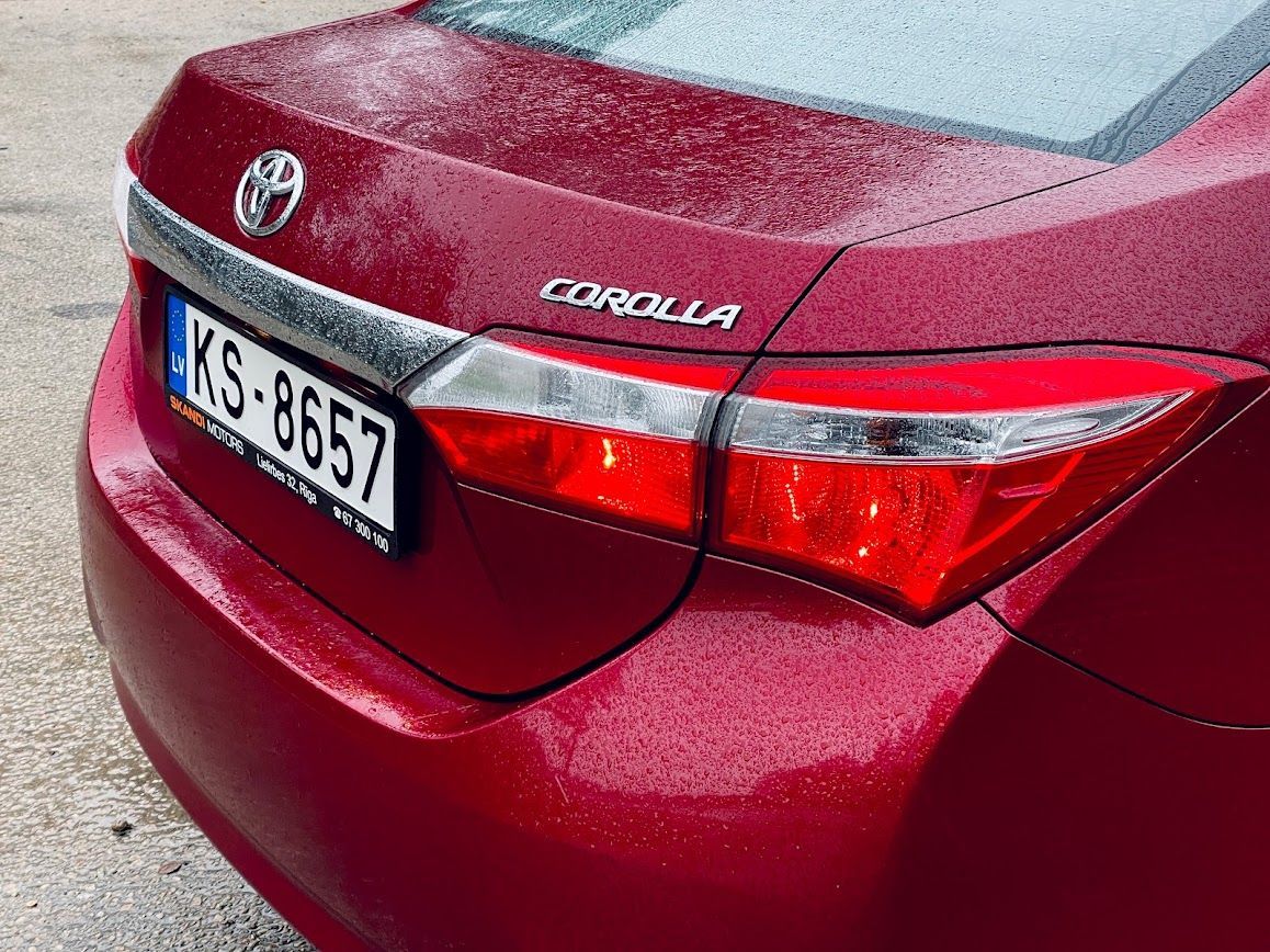 Parādīts sarkanās Toyota Corolla aizmugurējais gals.