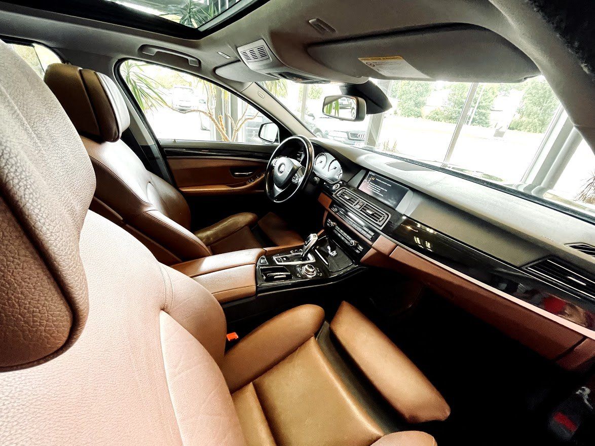 Automašīnas salons ar brūniem ādas sēdekļiem un jumta lūku