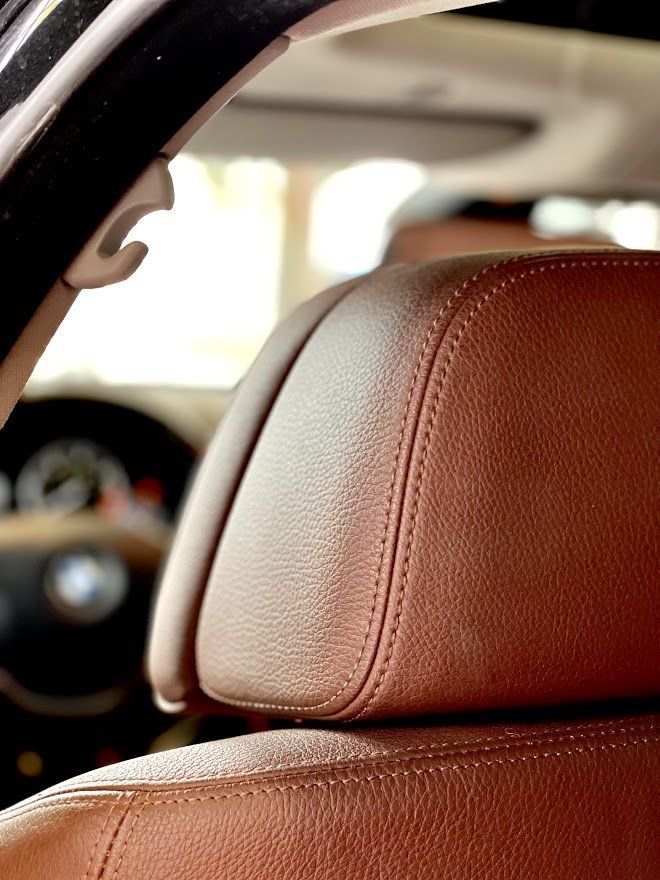 Tuvplāns ar brūnu ādas galvas balstu automašīnā