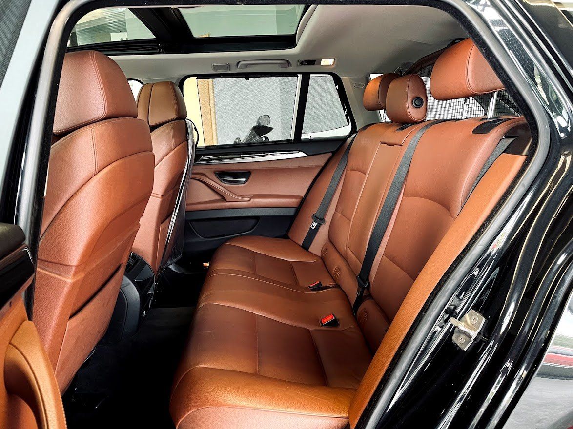 Melnas automašīnas aizmugurējais sēdeklis ar brūniem ādas sēdekļiem